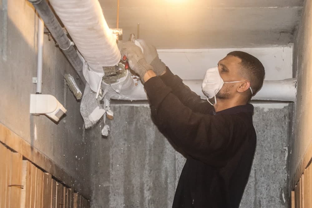 Ouvrier effectuant un calorifugeage réseau chauffage — Paris 5ème