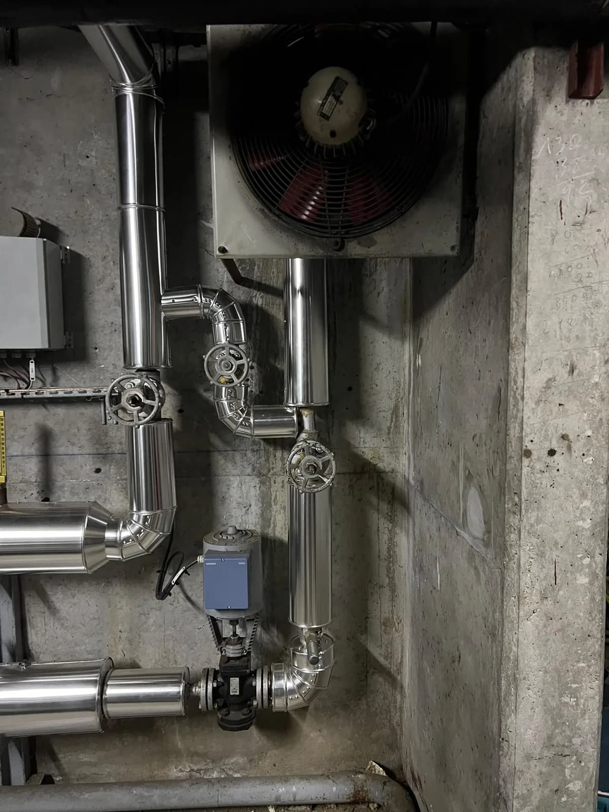 Coudes et tuyauteries habillés en tôle Isoxal autour des vannes dans une sous-station à Courbevoie